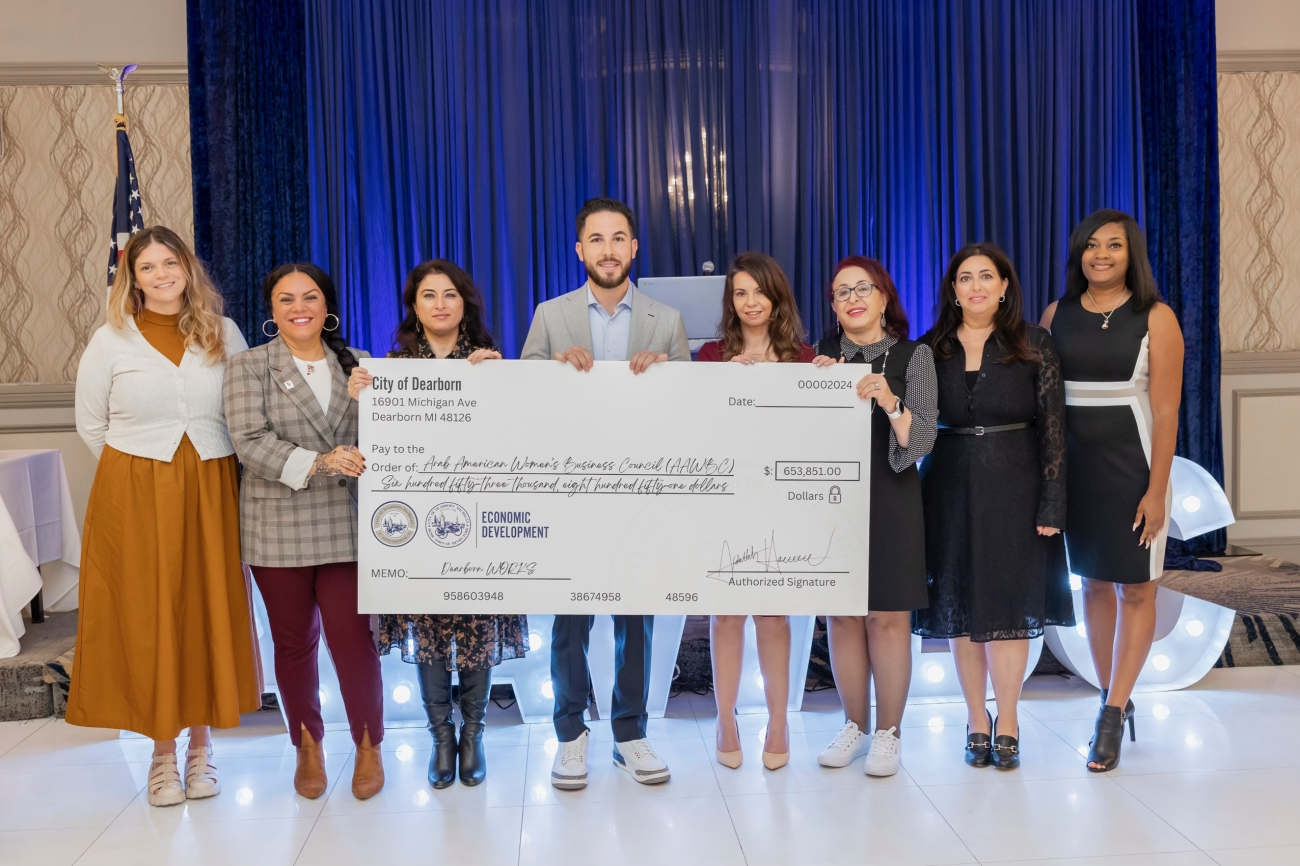 Photo caption: Mayor Abdullah H. Hammoud, Deputy Director of Economic Development Angela Fortino, and Dearborn Workforce Development Manager Dr. De’Janae Douglas present a check from the City of Dearborn and the Department of Labor to leaders of the AAWBC on Nov. 6, 2024. Photo Credit: Sahar Mashour, SM Photography.