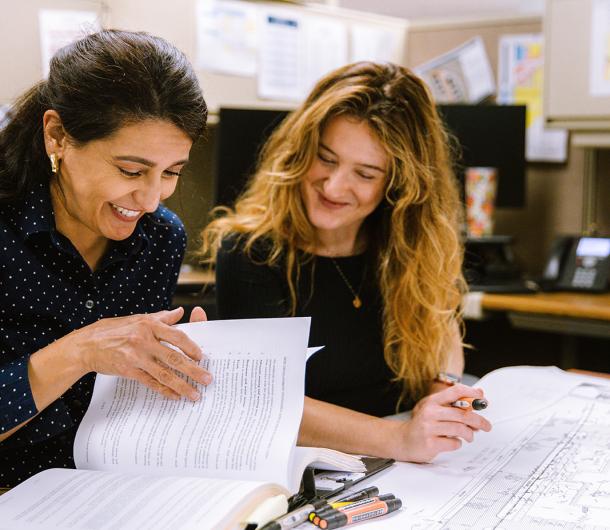 Two female City planners review City codes together
