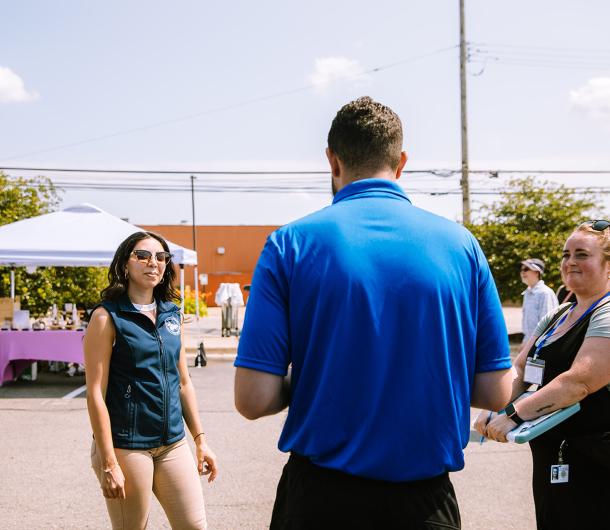 Staff members speak to a vendor at a City event. 